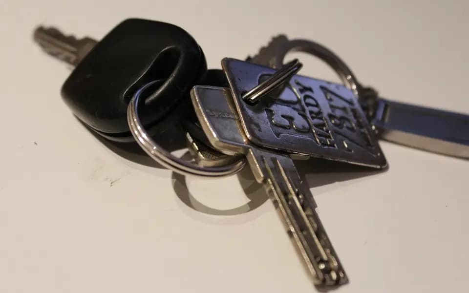 Pęk kluczy z metalową zawieszką na jasnym blacie